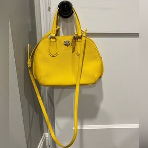 Coach yellow crossbody purse with gold accents and detachable strap